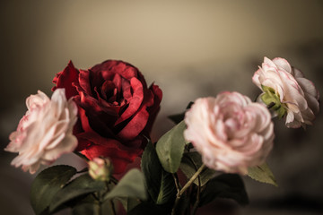 Blumenstrauß aus rosa und roten Stoffrosen, weicher und romantischer Vintage-Filter, der wie ein altes Gemälde aussieht, Blumenstillleben