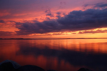 Amazing sunset over the lake.Landscape with a beautiful dramatic sunset sky after evening storm reflects in lake Mendota in the city of Madison Tenney Park,Wisconsin,USA.Long exposure horizontal shot.