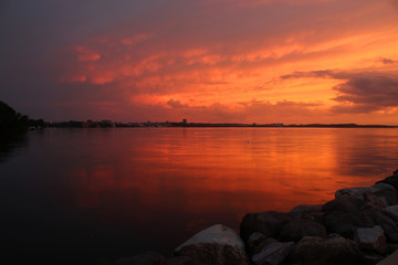 Amazing sunset over the lake.Landscape with a beautiful dramatic sunset sky after evening storm reflects in lake Mendota in the city of Madison Tenney Park,Wisconsin,USA.Long exposure horizontal shot.