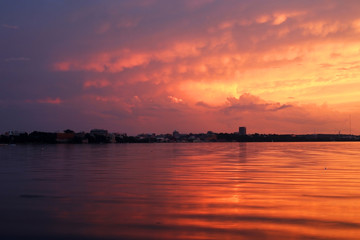 Fototapeta na wymiar Amazing sunset over the lake.Landscape with a beautiful dramatic sunset sky after evening storm reflects in lake Mendota in the city of Madison Tenney Park,Wisconsin,USA.Long exposure horizontal shot.