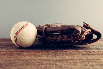 old Baseball and glove on wood background with filter effect retro vintage style