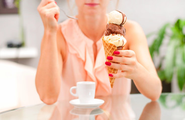 Woman eating chocolate ice cream cone.