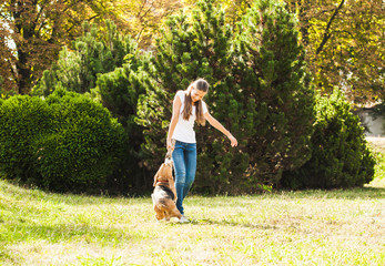 Fototapeta premium Girl plays with a dog in the yard