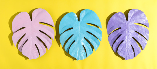 Painted tropical monstera leaves with hard shadow on a yellow background © Tierney