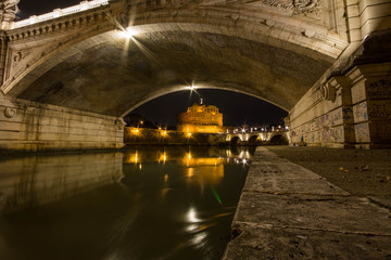 Castel sant'angelo with bridge shot at night from beneath the next bridge