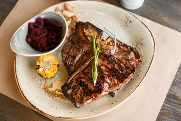 Grilled beefsteak with vegetables and herbs on plate