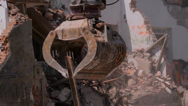 Excavator breaks the building. Old house destroyed, using a bulldozer.