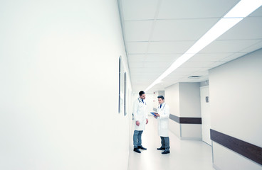 male doctors with clipboard at hospital corridor