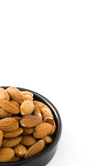 Almonds in black bowl isolated on white background