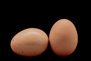 Two hen egg on black background with path