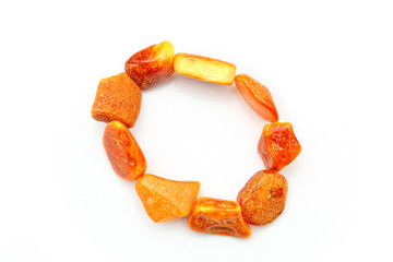 Amber beads made from natural pieces of amber on a white background. Jewelry for women from natural minerals. Petrified resin in the form of beads. Vintage decoration. Top view. Opaque amber