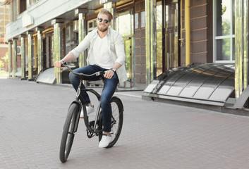 Fototapeta na wymiar Young man riding bicycle outdoors
