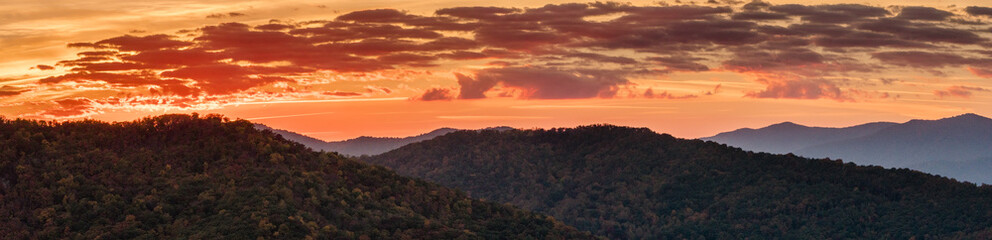 panoramic view of the rolling hills and forests in the Appalachian mountains during a spectacular orange morning sky and sunrise