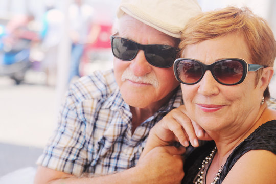 Portrait of senior couple sitting in summer cafe