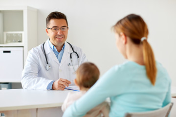 happy woman with baby and doctor at clinic