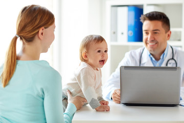 woman with baby and doctor with laptop at clinic