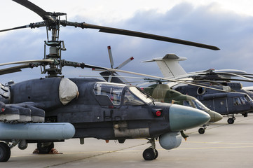 Obraz na płótnie Canvas Helicopters and planes in row, military copters and reconnaissance aircrafts, air force, modern army aviation and aerospace industry, dramatic clouds on background