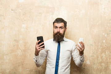 bearded man or hipster compare mobile phone and smartphone