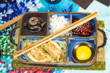 Chopsticks, rice, pork, pot stickers and hot mustard 