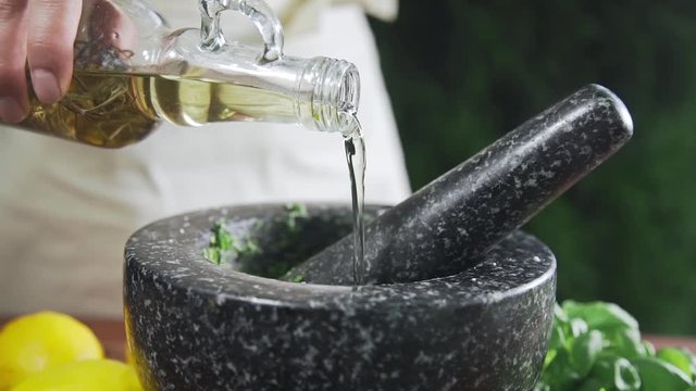 Housewife pours out the olive oil to the bowl, preparations before making barbecue, cooking outdoors, summer cooking, making the sauce