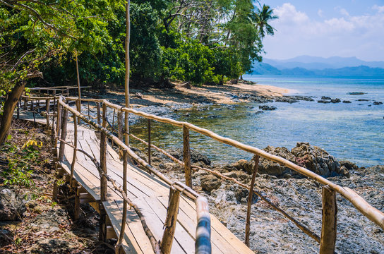 Bamboo path on tropical beach with palm trees, El Nido, Palawan, Philippines