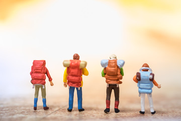 Travelling concepts. Group of traveler miniature mini figures with backpack standing on map