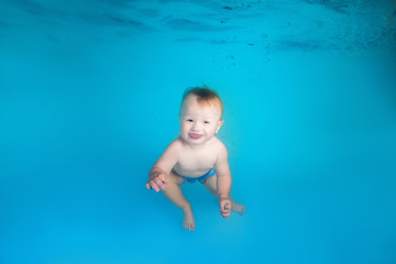 Fototapeta na wymiar little boy dives underwater in the swimming pool