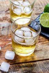 glass of whiskey on wooden background