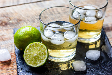 glass of whiskey on wooden background