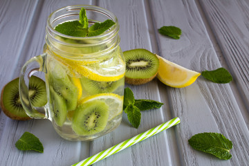 Detox water with kiwi and lemon on the grey wooden background