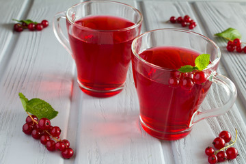 Red currant compote in two glass cups on the grey wooden background