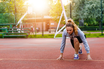 Athletic woman on running track getting ready to start run.