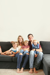 Young family with three boys lifestyle at home on the couch playing together