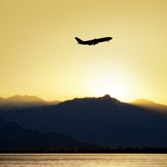 Fototapeta na wymiar commercial airplane flying during sunset