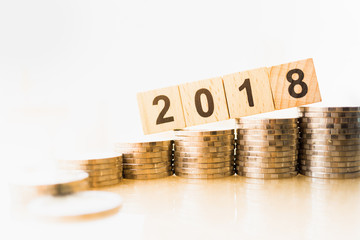 2018 New year and business target concept. Close up of 2018 number wooden block with stack of coins...