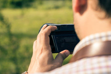 Young professional man with DSLR camera shooting outdoor.