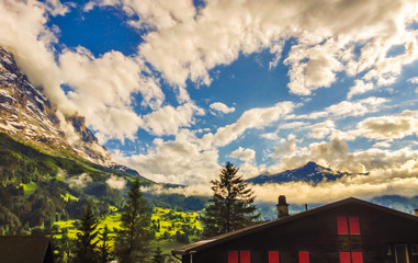 Majestic Panoramic view of Grindelwald Landscape and Cloudscape with golden light reflected, Canton of Berne, Bernese Oberland, Switzerland, Europe.. Starting village for First and Jungfraujoch.