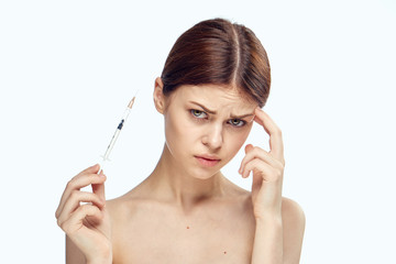 Beautiful young woman on white isolated background holds a syringe, medicine, plastic