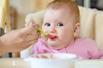 A cheerful happy child eats porridge.