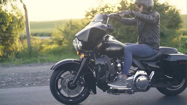 Stylish man on motorcycle in sunlight