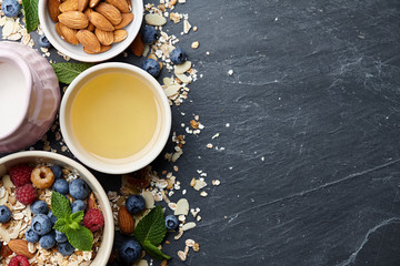 Healthy cereal breakfast with seasonal berries, almonds, farm milk and honey