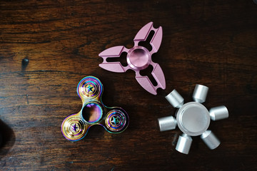 Hand spinners or fidgeting spinners. Various types and shapes of spinners put on the wood background. 