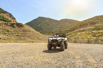 ATV offroad on mountain and sky background.