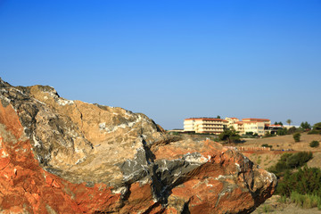 Ogromna skała, głaz w tle hotel, budynek, architektura na wyspie Rodos w Grecji. 