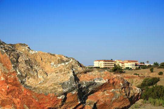 Ogromna skała, głaz w tle hotel, budynek, architektura na wyspie Rodos w Grecji. 