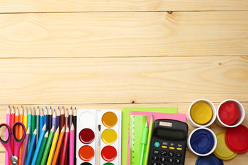 school and office supplies. school background. colored pencils, pen, pains, paper for  school and student education on wooden background. top view with copy space