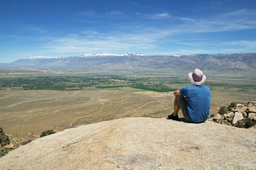 Fototapeta na wymiar Man Sits On Rock Overlook
