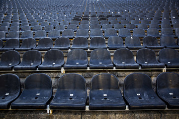 Naklejka premium Empty tribune with black seat on soccer sdadion