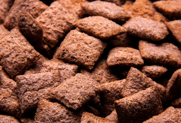 Chocolate breakfast cereal texture. Cereal balls as background. Chocolate corn balls wallpaper background cover. 