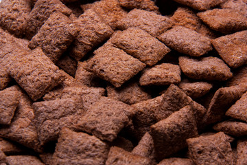 Chocolate breakfast cereal texture. Cereal balls as background. Chocolate corn balls wallpaper background cover. 